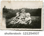 stock-photo-vintage-photo-of-mother-with-children-sitting-on-grass-fifties-121254937