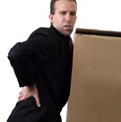 A man hurts his back lifting a large box.