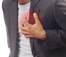 A man in a suit clutching his chest.