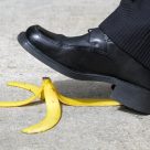 A shoe is about to step on a banana skin.
